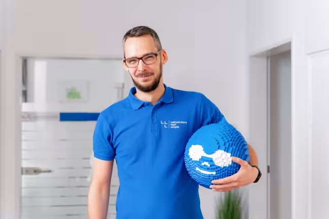 Drupal Webdesigner mit Druplicon im Arm